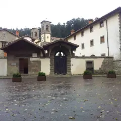Cortile umido con foglie cadute davanti all'ingresso di Camaldoli, dove si trova questo antico eremo.