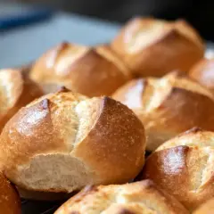 Une fournée de petits pains allemands dorés et croustillants, prêts à être dégustés.