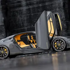 Szary Koenigsegg Gemera z otwartymi drzwiami, żółtym wnętrzem i złotymi zaciskami hamulcowymi. Czy to najszybsze auto na świecie?