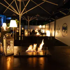 Gemütliche Atmosphäre mit Feuerstelle und Beleuchtung auf der Terrasse. Perfekt für Veranstaltungen in Bergisch Gladbach.