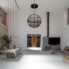 Geräumiger **Industrie-Loft** mit Betonwänden, großem Esstisch, Kamin und gemütlicher Sitzecke.