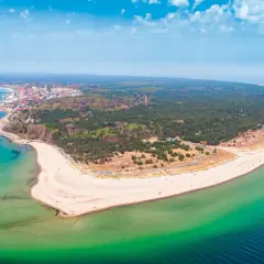 Półwysep Helski zachwyca szerokością plaż i lasów. Widok na miasteczko i turkusowe morze.
