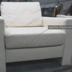 Ein weißer Ledersessel mit weichen Sitzpolstern. Hier wird gezeigt, wie man den Federkern eines Sofas reparieren kann.