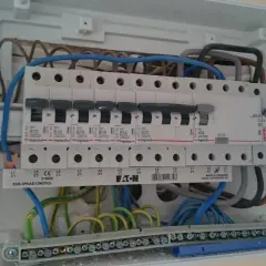 W skrzynce elektrycznej widać bezpiecznik przedlicznikowy 100A oraz szereg mniejszych bezpieczników.