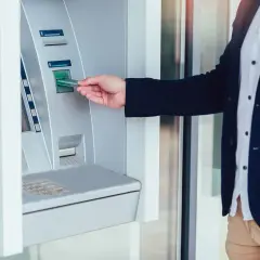 Mężczyzna wkłada kartę do wpłatomatu Peako, aby wpłacić pieniądze.