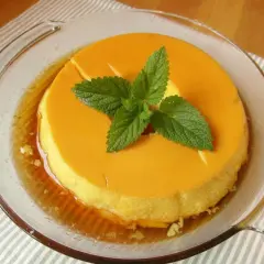 Delicioso flan de leche condensada al baño maría, decorado con hojas de menta fresca.