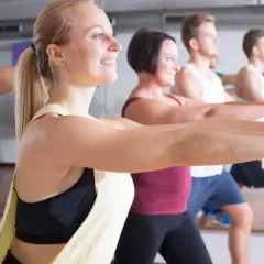 Ludzie na zajęciach zumbą, uśmiechnięci, wykonują ruchy. Zumbę co daje? Radość, energię i świetną sylwetkę!