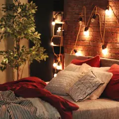 Atmosfera accogliente con luci soffuse e cuscini morbidi: ecco delle idee camera da letto per un relax totale.