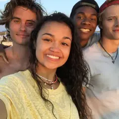 Uśmiechnięta **outer banks obsada** pozuje do selfie na plaży.