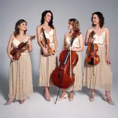 Elegancki kwartet smyczkowy w beżowych sukniach, gotowy do wykonania muzyki.