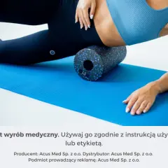 Kobieta używa rollera z wypustkami do masażu mięśni na niebieskiej macie.