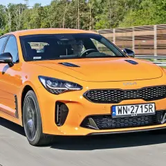 Pomarańczowy Kia Stinger na drodze. Sprawdź aktualną kia stinger cena i możliwości tego sportowego sedana.