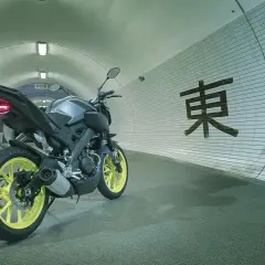 Yamaha MT-125 gris con llantas amarillas en un túnel con caracteres japoneses. ¡Lista para alcanzar su yamaha mt 125 velocidad maxima!