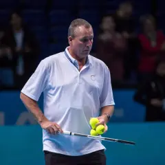 Ivan Lendl, były tenisista, trzyma rakietę i piłki tenisowe na korcie.