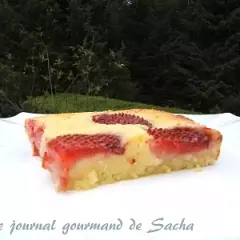 Un délicieux clafoutis aux fraises, tout juste sorti du four, sur une assiette blanche.