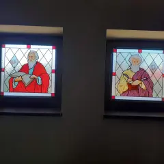 Witrazowe okna z wizerunkami ewangelistów: św. Mateusza z aniołem i św. Marka z lwem.