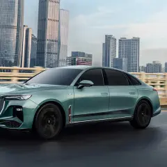 Elegancki, zielony Hongqi H9 jedzie po moście na tle drapaczy chmur. Sprawdź jego atrakcyjną hongqi h9 cenę!