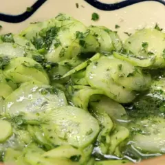 Frischer Gurkensalat ohne Essig, mit Dill und Petersilie, in einer Schüssel serviert.
