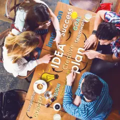 Zespół przy stole dyskutuje nad planem, rozwijając swoją kreatywność. Słowa "IDEA", "plan", "success" i "goal" tworzą mapę myśli.
