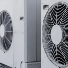 Rząd białych jednostek zewnętrznych, gdzie pompa ciepła i klimatyzacja pracują razem, zapewniając komfort.