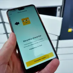 Dłoń trzyma smartfon z aplikacją InPost informującą o otwartej skrytce.