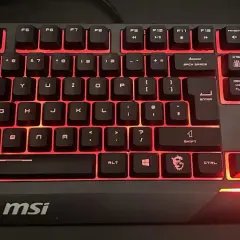 Klawiatura MSI z podświetleniem fn na klawiaturze. Czerwone światło emanuje spod klawiszy, tworząc futurystyczny wygląd.