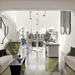 A modern living space with green marble floors and a striking staircase, feeling chic by accident in Mexico City.