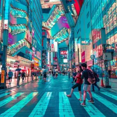 Neonowe centrum Tokio, Akihabara, tętni życiem. Ludzie przechodzą przez mokre pasy, otoczeni przez kolorowe reklamy i futurystyczną architekturę.