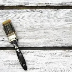 Pennello sporco su assi di legno bianco, pronto per la cementite per legno già verniciato.