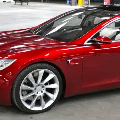 Czerwony Tesla, który mąż nie chce dać mi samochodu, lśni w słońcu.