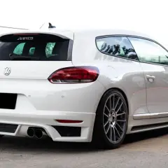La parte posteriore di una Volkswagen Scirocco bianca, con un diffusore sportivo e quattro scarichi.