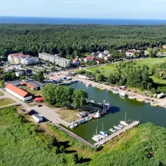Widok na przystań jachtową i zabudowania w otoczeniu zieleni, idealne miejsce na camping Mierzeja Wiślana.