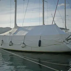 Barca a vela coperta con un telo per barca fai da te, pronta per l'inverno.