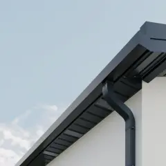 Nowoczesne, ciemne rynny kolory idealnie komponują się z jasną elewacją i błękitnym niebem.