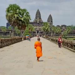 Mnich w pomarańczowej szacie idzie do Angkor Wat, wspaniałego miejsca na kambodżańskie wakacje.