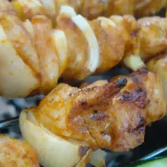 Szaszłyki z kurczaka i cebuli, idealnie przypieczone na grillu. Dowiedz się, jak pokroić cebulę do szaszłyków, by uzyskać taki efekt.