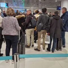 Kolejka pasażerów z bagażami na lotnisku w Izraelu.