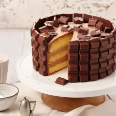 Eine köstliche Kinderriegel Torte, umhüllt von Schokoriegeln und garniert mit Stückchen. Ein Traum für jeden Schokoladenliebhaber!