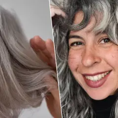 Una mujer sonríe mostrando su cabello con canas, que luce rizado y con mechones plateados.