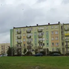 Bloki mieszkalne w Łodzi, z widocznym szyldem "SPRZEDAM". Ceny mieszkań w Łodzi mogą być różne, ale te budynki wyglądają na typowe dla osiedli z lat 70.
