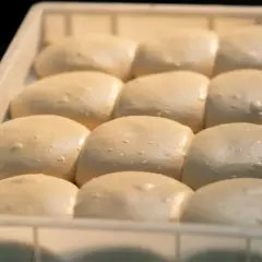 Gotowe do pieczenia ciasto na pizzę w lodówce. Porcje ciasta czekają na swoją kolej, by stać się pyszną pizzą.