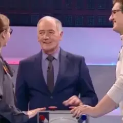 Trzy osoby na planie teleturnieju Familiada: prowadzący i dwoje uczestników.