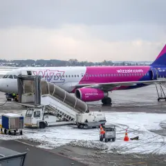 Samolot Wizz Air na lotnisku zimą. Zastanawiasz się, ile się płaci za nadbagaż Wizzair? Sprawdź przed podróżą!