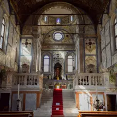 Intérieur de l'église Santa Maria dei Miracoli à Venise, avec son escalier rouge menant à l'autel, le tout orné de marbre.