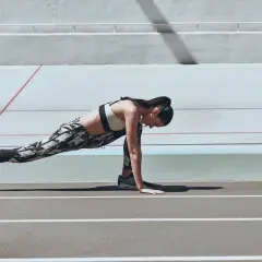 Kobieta wykonuje ćwiczenie typu stretching na bieżni.