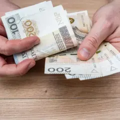 Ręce liczą banknoty 100 i 200 zł. To może być budżet na wczasy pod gruszą zasady.