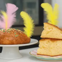 Deliciosa receta mona de pascua esponjosa, decorada con plumas de colores y chispas. ¡Perfecta para compartir!