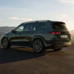 Mercedes más potente, un SUV oscuro aparcado en una colina con vistas a un valle al atardecer.