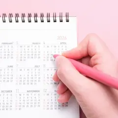 Dłoń z różowym długopisem zaznacza datę w kalendarzu na 2026 rok. Zastanawiasz się, ile trwa sprawa cywilna? Czas może być różny.