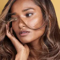 Morena con cabello castaño y reflejos caramelo, un estilo que ilumina su rostro.